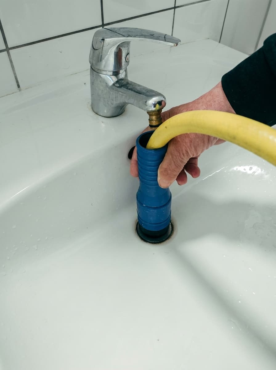 Echtes Einsatzfoto von Kanalrein: Wasserdüse mit Schlauch direkt am Abfluss – Rohrreinigung nur mit Wasser, ganz ohne Chemie